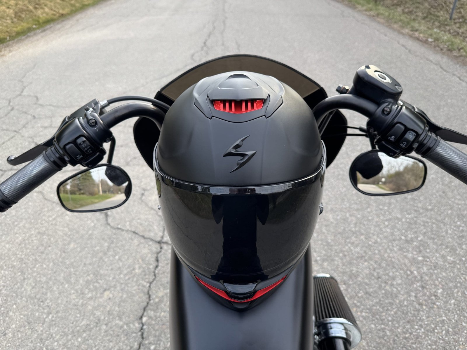 Scorpion EXO-Eclipse Solid helmet resting on the gas tank of a Harley Davidson