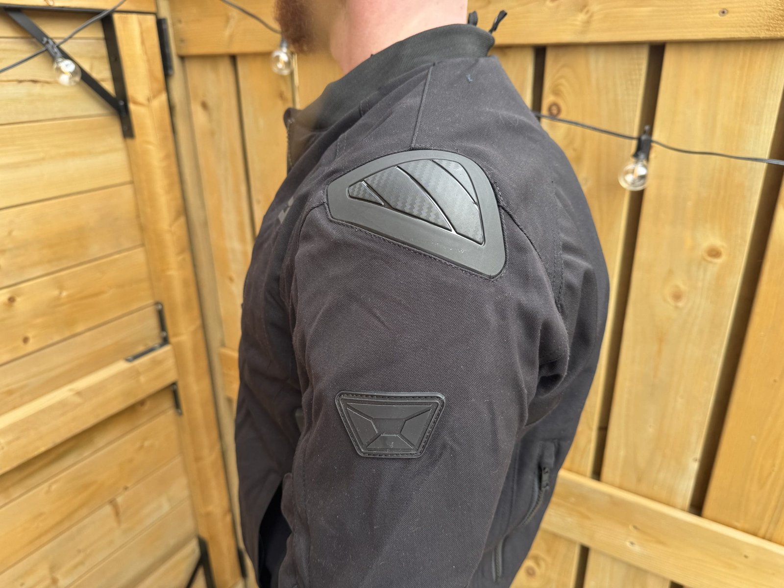 Shoulder view of the Versa-Flo Jacket showcasing the hard plastic slider and logo