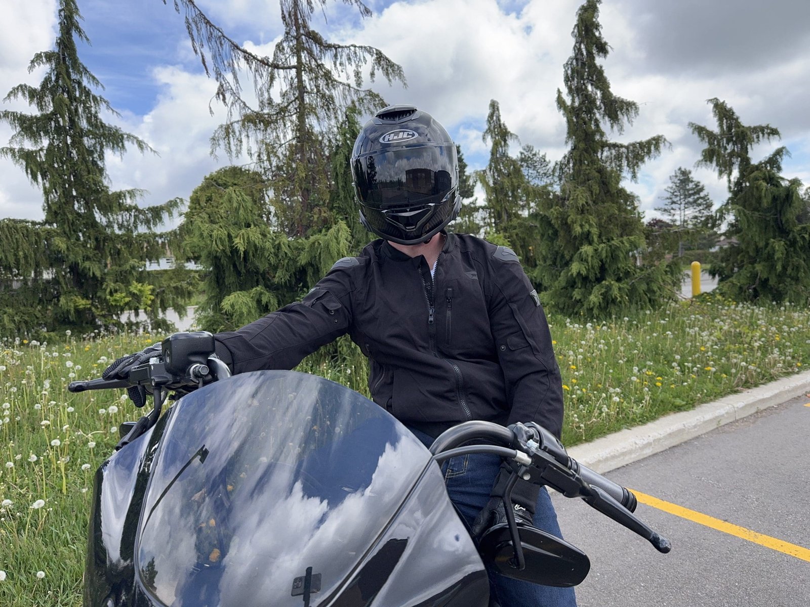 Rider sitting on a motorcycle wearing the HJC RPHA 71 Carbon helmet
