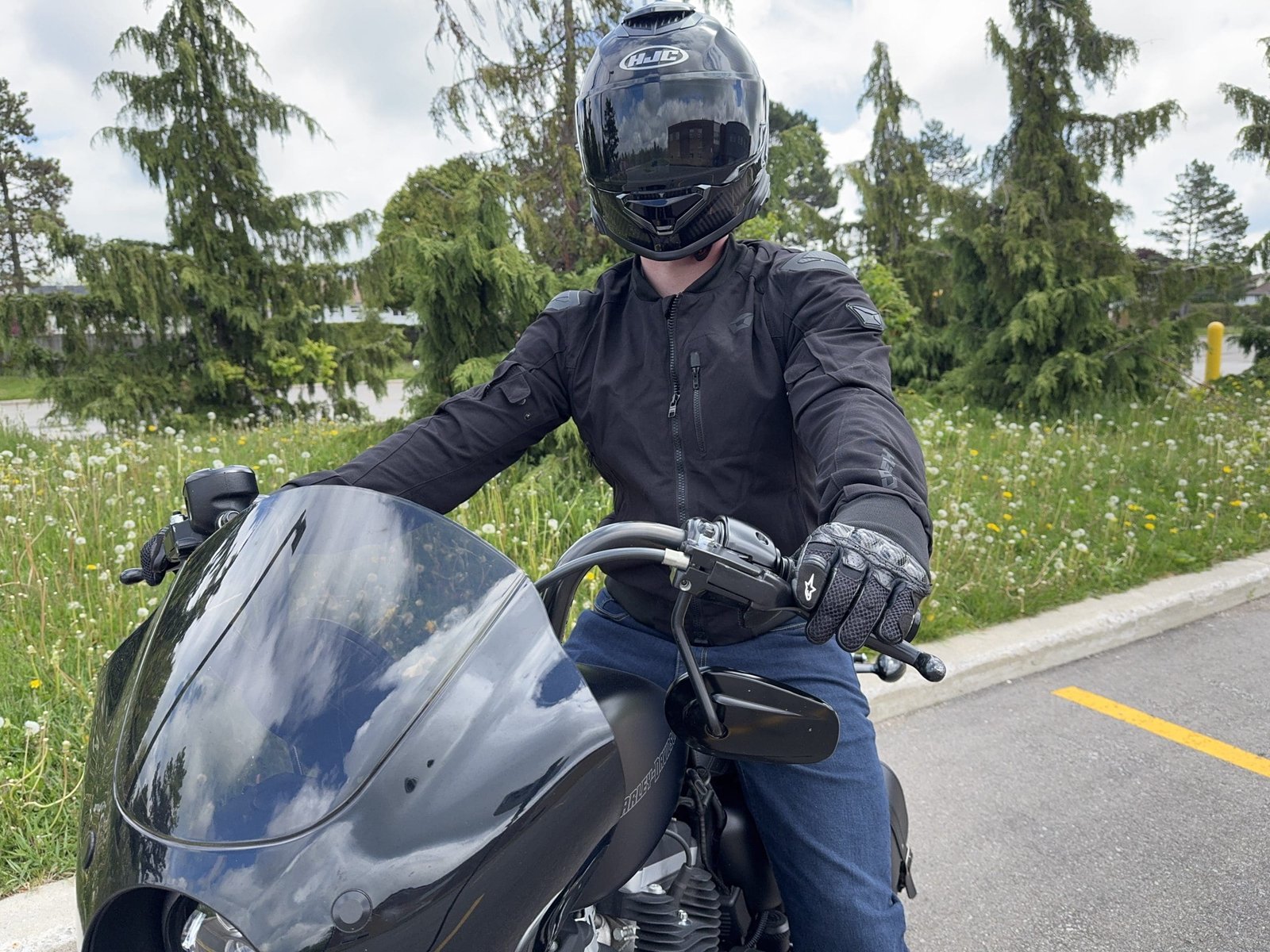 Rider sittong on a motorcycle wearing the HJC RPHA 71 Carbon helmet