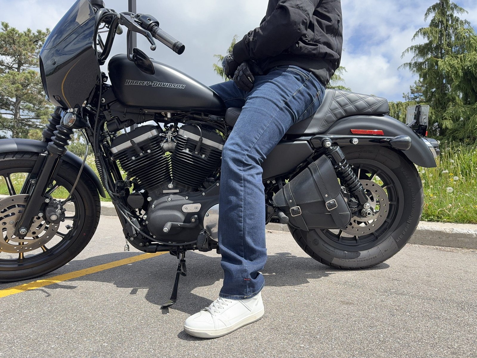 Rider wearing the Klim K Forty 2 Stretch Denim Jeans sitting on a Black Harley Davidson