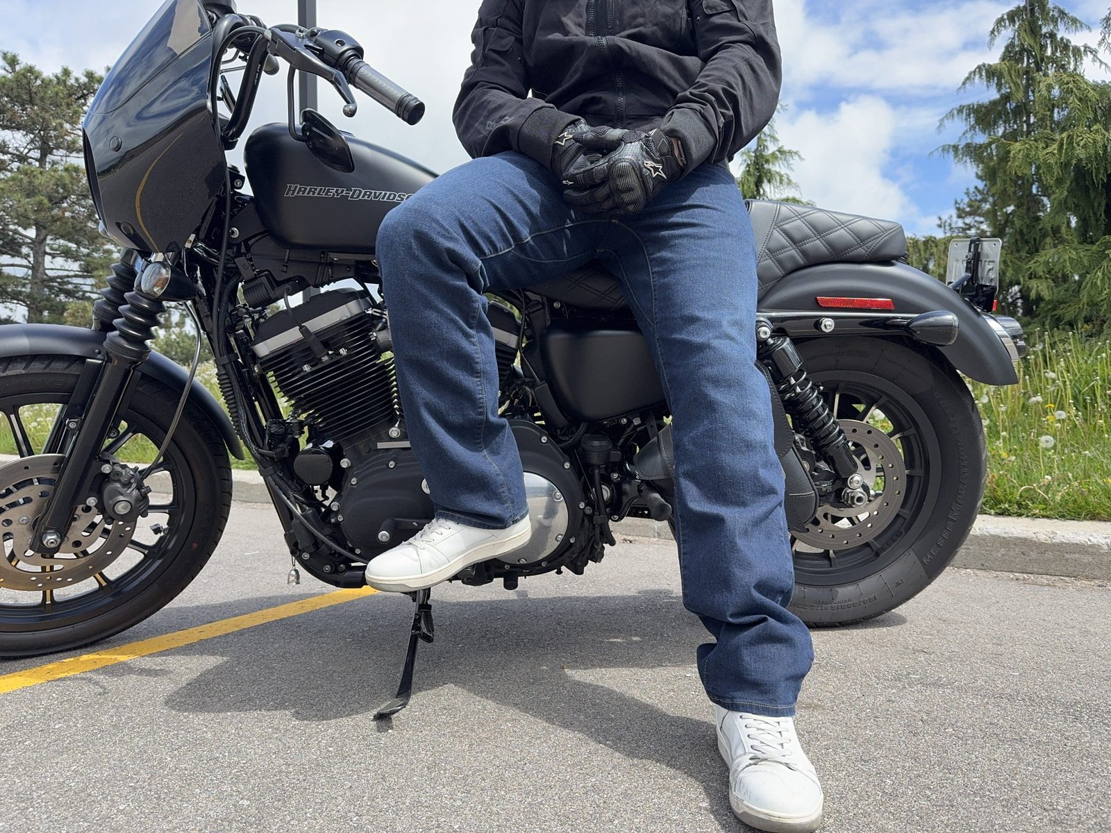 Rider sitting on a Harley Davidson wearing the Klim K Forty 2 Stretch Denim jeans