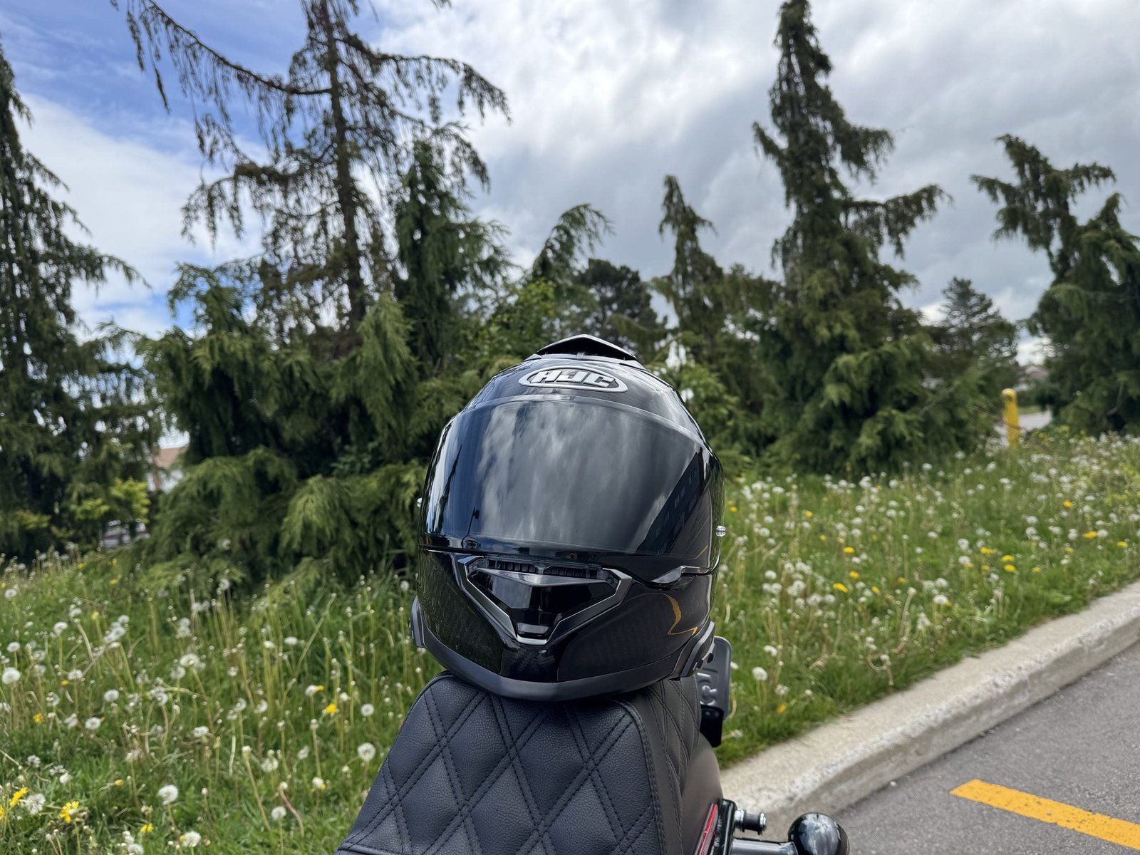 Compatible SMART HJC helmet RPHA 71 Carbon resting on a motorcycle