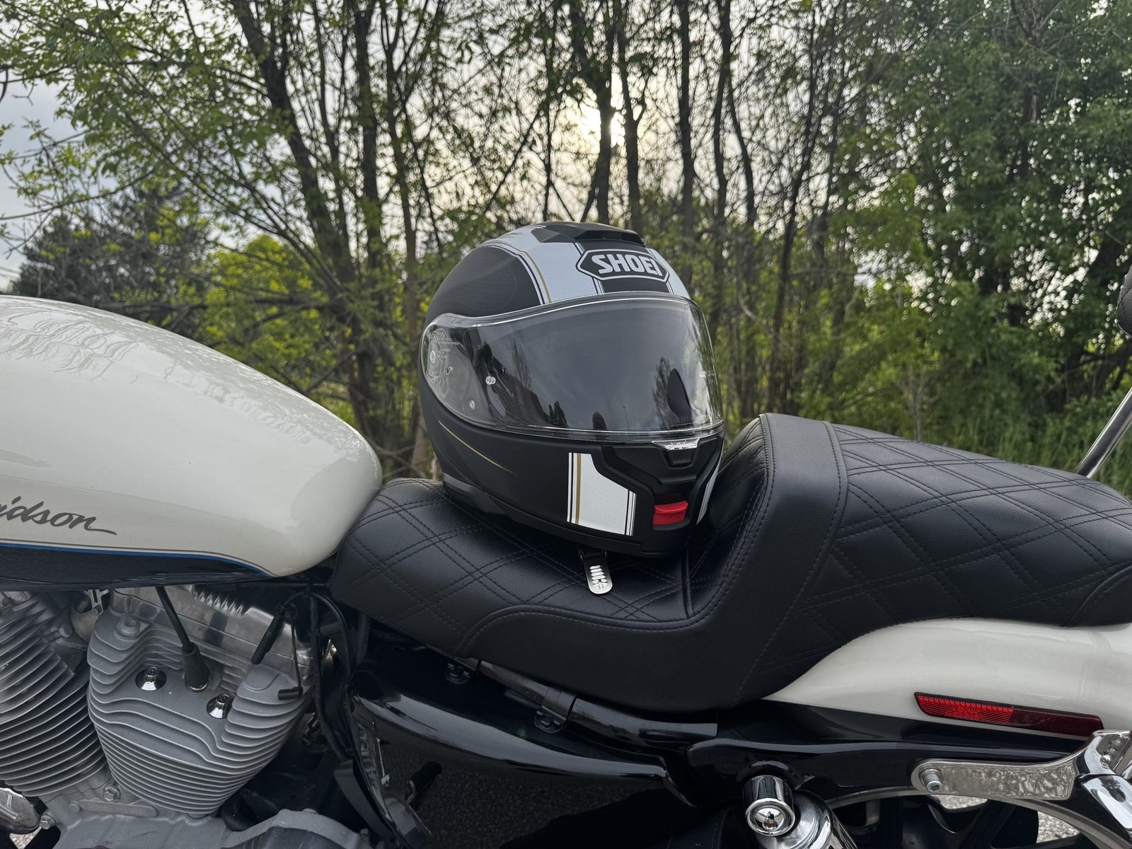Shoei Neotec 3 Satori TC-5 Helmet resting on saddlemen seat of harley davidson sportster 883