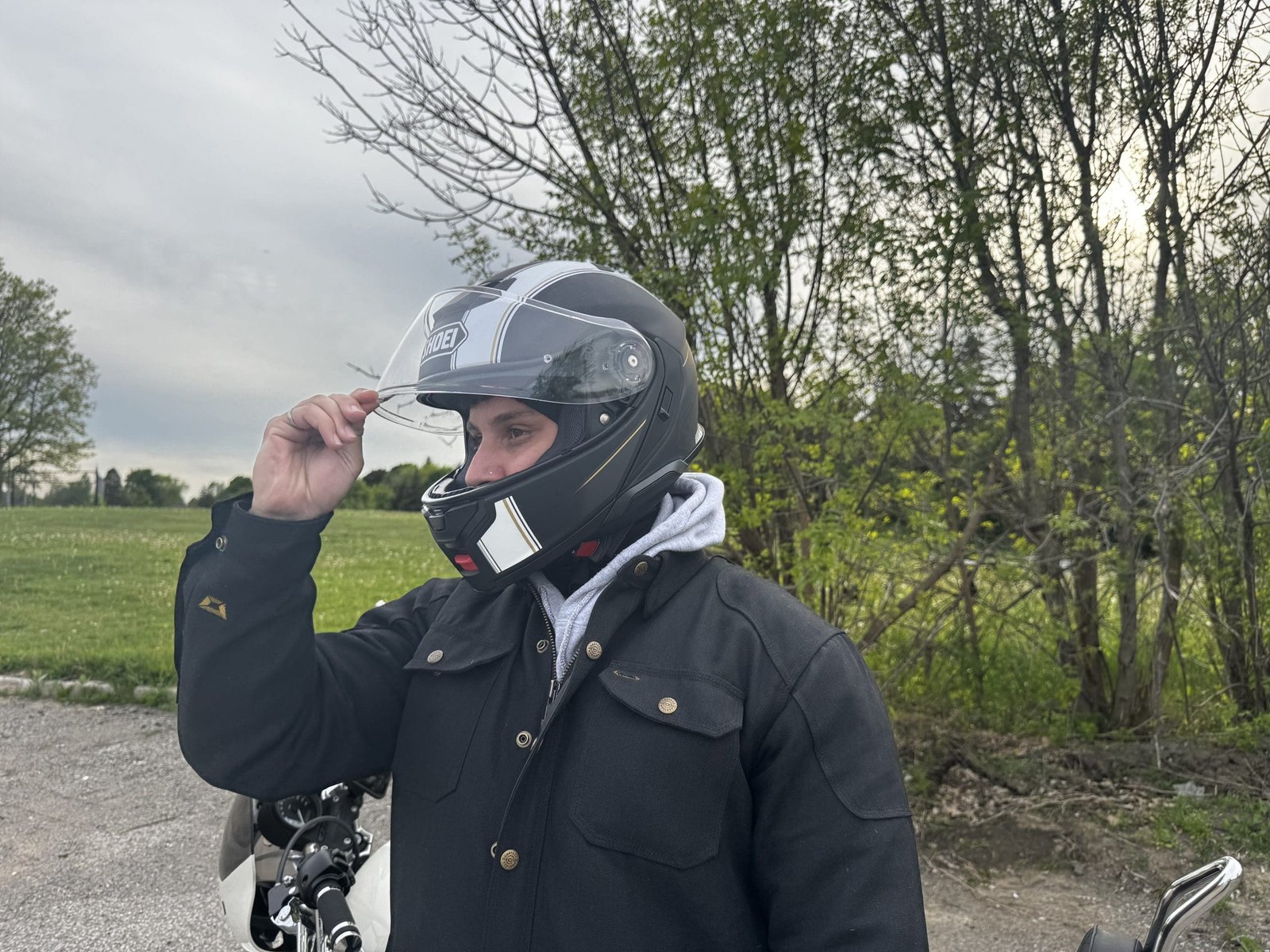 motorcycle rider adjusting visor of Shoei Neotec 3 Satori TC-5 Helmet