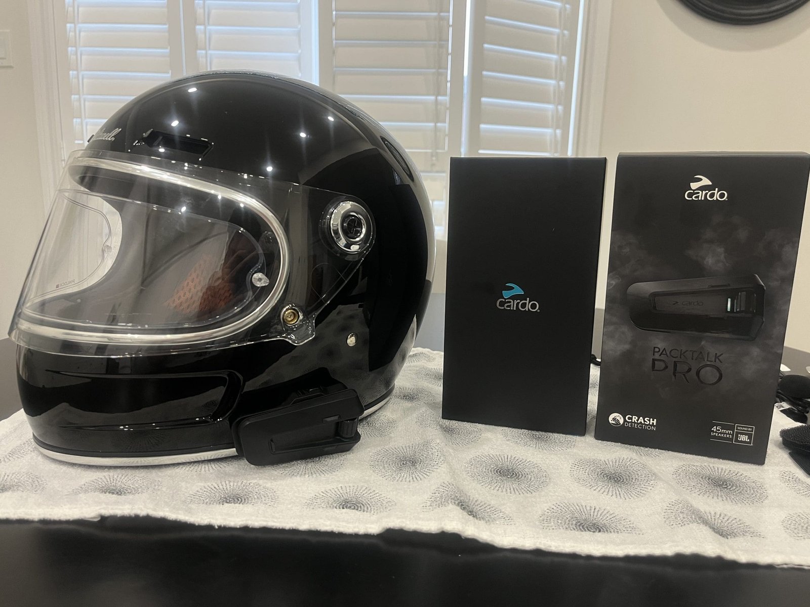 Cardo Packtalk Pro installed on biltwell gringo SV with packaging beside the helmet