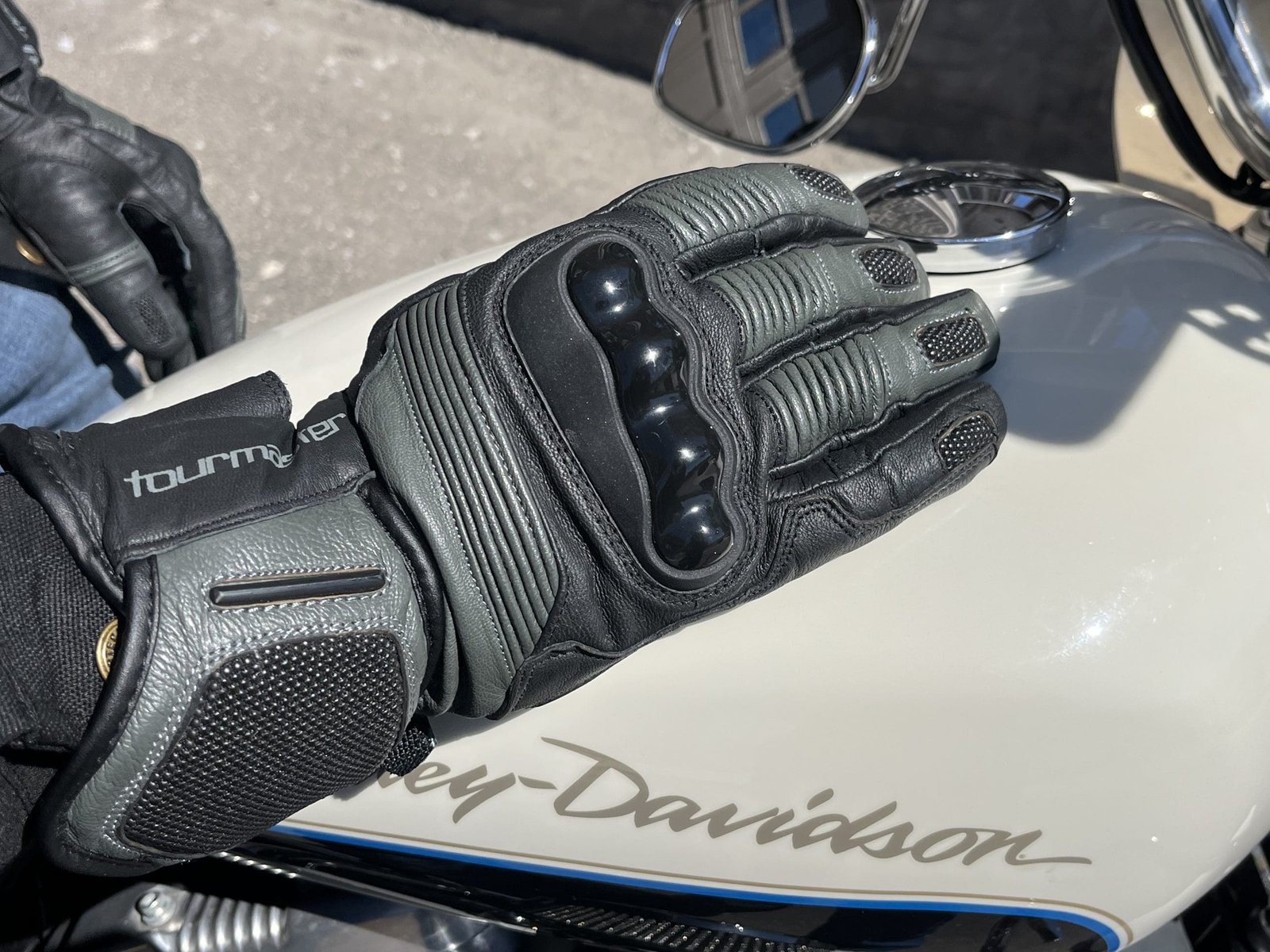 a motorcycle rider resting his hand on his harley davidson tank wearing the TOURMASTER Super Warm Waterproof Gloves