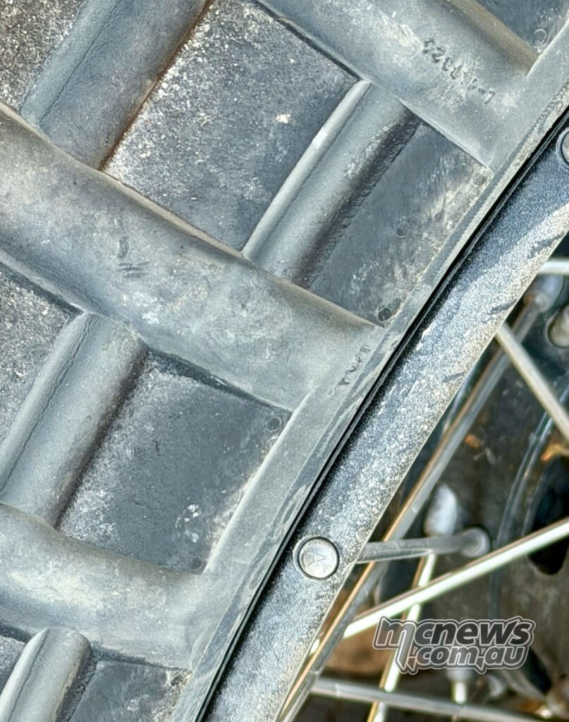 Close-up of a dusty Continental TKC 80² tread on a spoked wheel rim after off-road use.