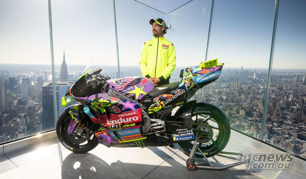 VR46 rider standing behind the special-livery Ducati MotoGP bike at a New York rooftop launch event.