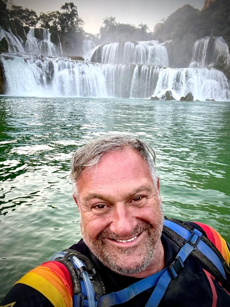 The Quay Son River originates in China and flows to the fourth largest transnational waterfalls in the world, the Ban Gioc Falls in Trung Khanh. On the south side of the river is Vietnam and on the north side of the river, China. The author musters a smile despite a few broken ribs.