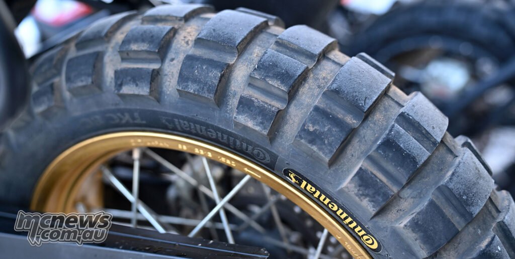 Close-up of a Continental TKC 80² adventure motorcycle tyre fitted to a gold spoked rim.