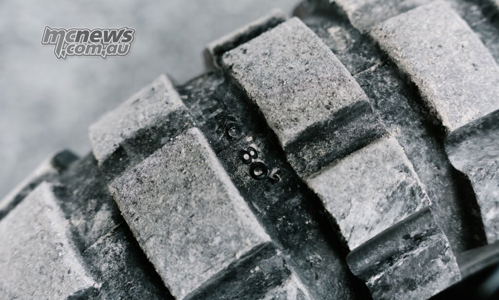 Macro image of the Continental TKC 80² tread blocks covered in light dust.