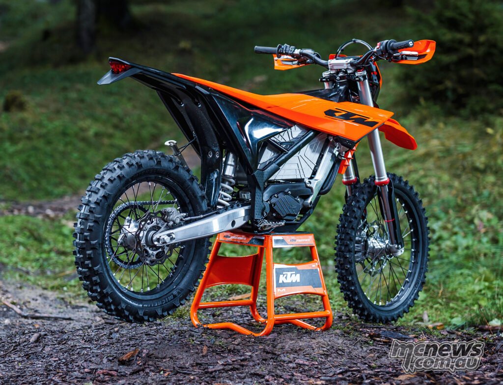 Right-rear three-quarter view of the 2027 KTM Freeride E on a stand in a forest clearing.