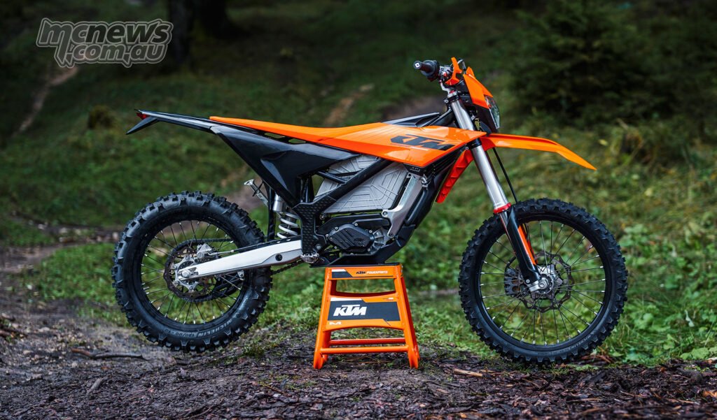 Full left-side profile of the 2027 KTM Freeride E with off-road tyres and orange bodywork.